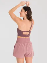 Top deportivo de un hombro con diseño ajustado, confeccionado en tejido técnico con soporte bajo y almohadillas removibles.