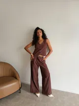 Chaleco de corte sastrero en tela tusor color beige con sutiles rayas verticales, escote en V y cierre frontal con botones al tono.