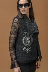 Chaleco de paño gris oscuro con textura jaspeada, cuello solapa amplio y bordado artístico en hilo claro en el frente.