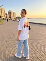 Remera blanca de corte holgado con estampado de un auto Ferrari rojo y texto "Vinnare Luxury".