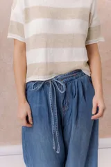 Jean de calce amplio y relajado, color azul, con pierna extra ancha y caída fluida. Diseño de tiro alto con pinzas delanteras y lazo regulable en la cintura. Cuenta con bolsillos laterales y traseros.