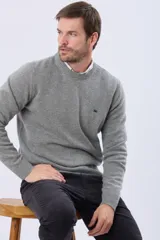 Buzo tejido de lana con escote redondo a la base y mangas largas. Presenta un diseño clásico y minimalista con un pequeño logo bordado en el pecho.