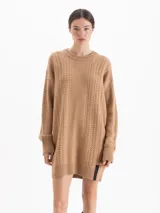 Sweater de punto largo con diseño de trenzas verticales, cuello redondo y mangas largas con puños acanalados. Presenta una silueta holgada y un detalle de etiqueta en el ruedo.