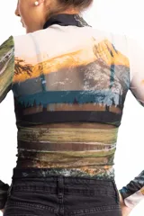 Remera crop top de mangas largas y cuello alto, confeccionada en tejido de red transparente con estampado de paisaje montañoso.