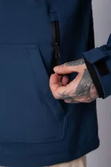 Campera de abrigo color azul, con cierre frontal, capucha ajustable y bolsillos laterales con cierre. Presenta un diseño minimalista con detalle de logo circular en la manga.