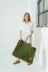 Bolso grande de fieltro color verde oliva con asas de cuero marrón.