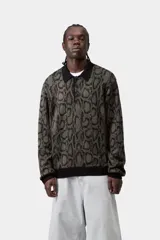 Sweater de punto con diseño de piel de serpiente en tonos verdes y negros, manga larga, cuello polo negro y cierre de botones frontal.