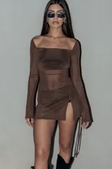 Vestido corto de tul marrón, de manga larga acampanada con cintas colgantes y escote cuadrado, con diseño semitransparente y tajo lateral en la falda.