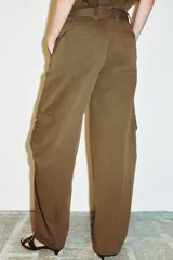 Pantalón de tiro alto con diseño tipo cargo, pernera holgada que se estrecha hacia el tobillo, bolsillos laterales con cierre y bolsillos de plastrón con solapa.