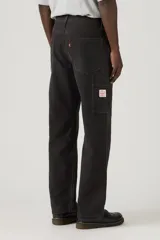 Pantalón tipo carpenter de corte holgado y recto, con diseño de cinco bolsillos y costuras reforzadas características del estilo utilitario.
