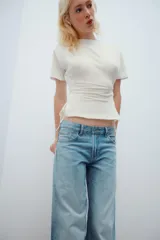 Jeans de tiro bajo y cinco bolsillos, con diseño de pierna ancha y larga, de color celeste con efecto desgastado. Cuenta con detalle de estrella bordada con brillos en el bolsillo delantero.