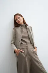 Chaqueta corta color marrón con cuello solapa y diseño con patchwork de telas. Manga larga con detalle de coderas aplicadas. Cierre frontal mediante botones y bolsillos ojal. Con forro.