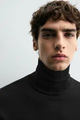 Jersey negro de punto fino con cuello alto y manga larga.