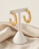 Aros tipo argolla de acero con baño de oro, con diseño texturizado de líneas verticales en relieve.