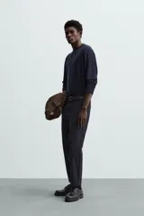 Pantalón chino de corte slim fit, confeccionado en tejido elástico. Presenta bolsillos frontales, bolsillos traseros de vivo con botón y cierre frontal con cremallera y botón.
