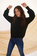 Sweater negro de tejido de punto con cuello alto y mangas largas.