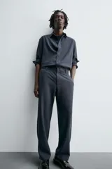 Pantalón de corte relaxed fit, con cintura ajustable, bolsillos delanteros y bolsillo trasero de plastrón. Presenta cierre frontal con cremallera y botón.