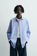 Camisa slim fit de algodón color celeste, con cuello italiano, manga larga y puños con botón. Cierre frontal de botonadura.