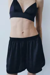 Short liso de tejido satinado color azul marino, de tiro medio con cintura elástica y botones frontales ocultos bajo sopata.