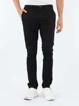 Pantalón de corte slim Calvin Klein, confeccionado en mezcla de algodón elástico. Presenta cierre de botón y cremallera, con diseño sólido y versátil.