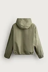 Cazadora de denim de algodón color negro con efecto lavado, de corte relaxed fit, manga larga y capucha. Cuenta con cierre frontal de cremallera, bolsillos frontales tipo canguro y acabados con elástico en puños y cintura.