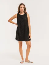 Vestido corto negro con bordado floral, sin mangas y escote redondo.