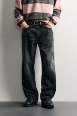 Jeans de denim de algodón en color azul con efecto desgastado, tiro medio y corte recto de ajuste holgado (loose fit). Cuenta con diseño clásico de cinco bolsillos y cierre frontal con cremallera y botón.
