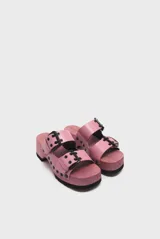 Sandalias de madera color rosa con plataforma y dos tiras de cuero rosa con hebillas negras.
