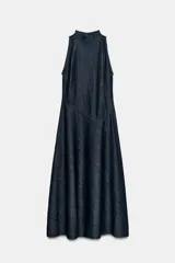 Vestido midi de denim oscuro con cuello perkins y diseño sin mangas. Presenta un corte entallado en el torso con una costura diagonal en la cintura y falda acampanada en línea evasé. Cierre posterior con cremallera metálica.