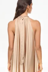 Vestido largo de viscosa color bordó, con cuello halter alto, corte holgado y volante fruncido en el bajo.