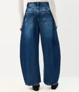 Pantalón barrel de jean color azul con lavado medio, cintura alta, recortes laterales y bolsillos funcionales.