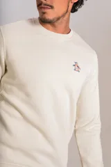 Buzo de cuello redondo color crudo, con detalle de logo bordado en el pecho, mangas largas y puños elastizados.