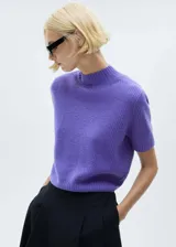 Jersey de punto de lana en color violeta, con cuello perkins y manga corta. Presenta un diseño recto y tejido de punto medio.