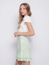 Minifalda verde con estampado de flores blancas y volados en el ruedo.