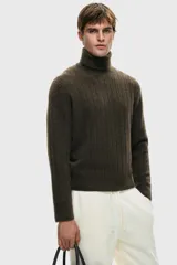 Polera de punto texturizado en color marrón oscuro, con cuello alto acanalado y puños y bajo con terminación acanalada. Presenta un corte estándar.