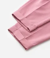 Pantalón de sastrería modelo carrot, color rosado, con corte holgado en la cadera que se afina hacia el tobillo. Presenta cintura alta, bolsillos laterales y terminación con dobladillo en el bajo.