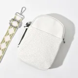 Porta celular blanco de cuero sintético con textura perforada, cierre superior con cremallera y correa de tela estampada ajustable y desmontable.