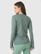 Polera de manga larga deportiva en color verde melange, con cuello redondo y diseño ajustado. Presenta aberturas para los pulgares en los puños y un pequeño logo bordado en el pecho.
