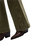 Pantalón de jean verde militar, corte ancho y relajado, con detalles de costuras reforzadas en rodillas y botones decorativos en los tobillos.