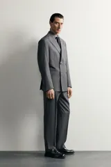 Blazer regular fit de Zara confeccionada en 100% lana, de color gris con diseño de rayas diplomáticas. Presenta cuello con solapas de pico, manga larga con botones en los puños, bolsillos con solapa en la cadera y bolsillo de vivo en el pecho. Cuenta con cierre frontal de botonadura cruzada.