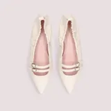 Bailarinas de punta fina color marfil con dos tiras horizontales y hebillas metálicas.