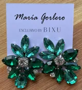 Par de caravanas con forma de flor, con pétalos de diferentes tamaños y colores: fucsia, violeta y rojo. En el centro tienen un cristal facetado y pequeños strass blancos.