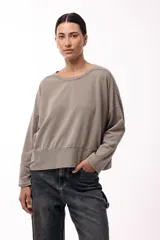 Remera de silueta amplia con hombro caído y cuello redondo, confeccionada en tejido suave de algodón. Presenta un diseño holgado y versátil con mangas largas.