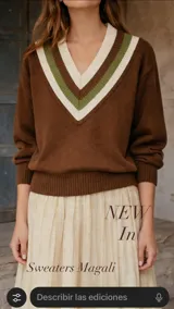 Sweater de punto color marrón con cuello en V, decorado con franjas en tonos crema y verde. Presenta mangas largas con puños acanalados y un diseño holgado con cintura ajustada.