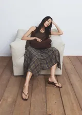 Falda midi evasé de tiro medio, con estampado de cuadros, bajo asimétrico y cierre de cremallera lateral. Cuenta con forro interior.