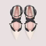 Ballerinas color crema de piel, con punta fina y lazo negro que se ata al tobillo.