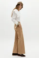 Pantalón de corte recto y pierna levemente ancha, confeccionado en pana de algodón color camel. Presenta cintura media, cierre frontal con gancho oculto y bolsillos laterales y traseros.