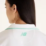 Remera deportiva tipo polo de manga corta, color blanco con detalle de ribete en color verde menta en el cuello. Presenta un diseño de cuello en V y corte entallado.