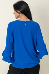 Blusa azul royal de mangas 3/4 con volados y cuello redondo.