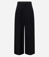 Pantalón de sastrería negro de modelado amplio, con pinzas frontales y cintura con pasadores.